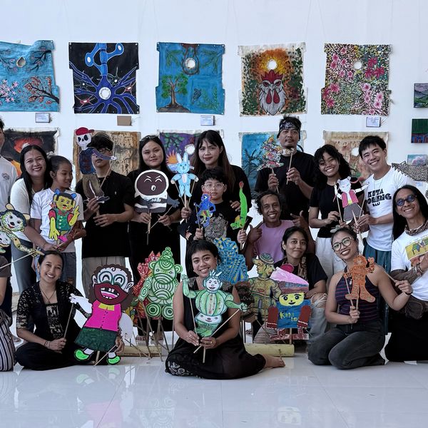 Workshop participants holding up their wayang puppets in a big group photo